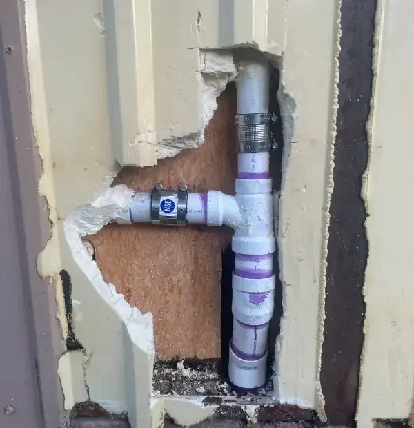 Repaired supply lines exposed in an opened interior wall