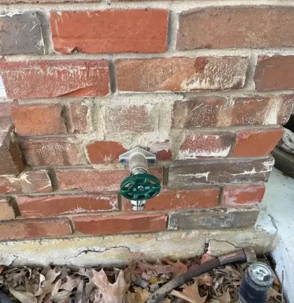 Exterior hose bibb and shutoff on a brick wall