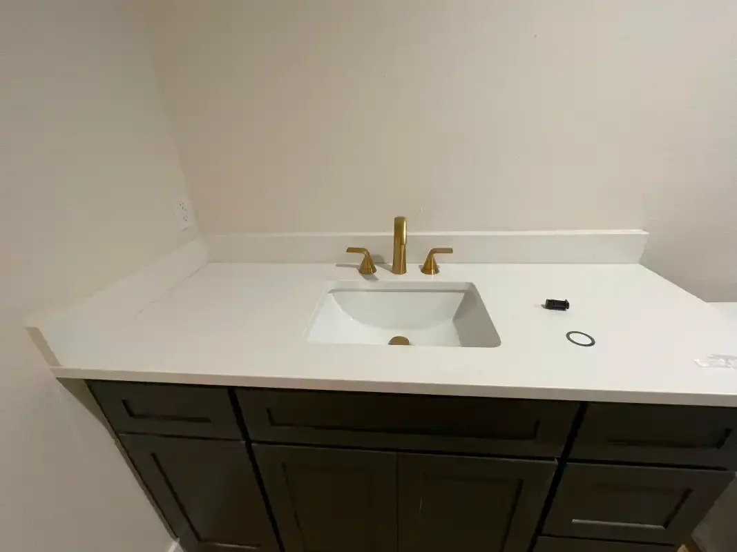 New vanity top with a brass faucet and undermount basin