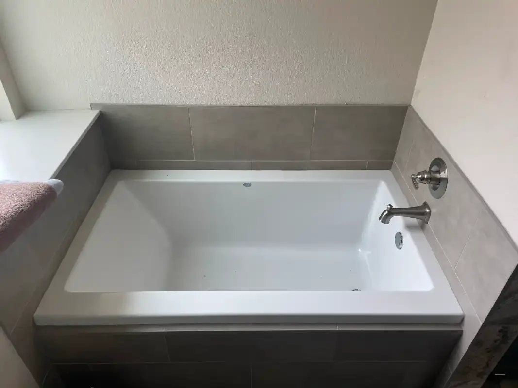Alcove soaking tub with tile surround and chrome spout