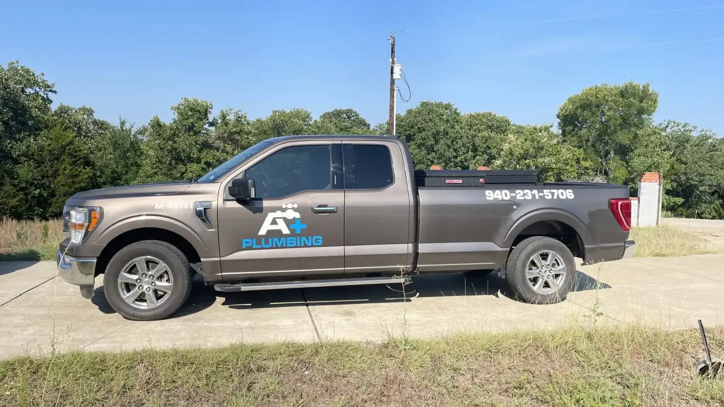 A+ Plumbing branded pickup truck parked on a job site