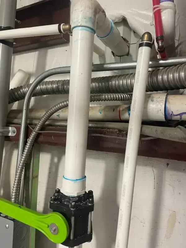 Overhead commercial supply piping with a green-handled shutoff