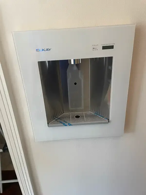 Recessed stainless water dispenser unit set into a wall