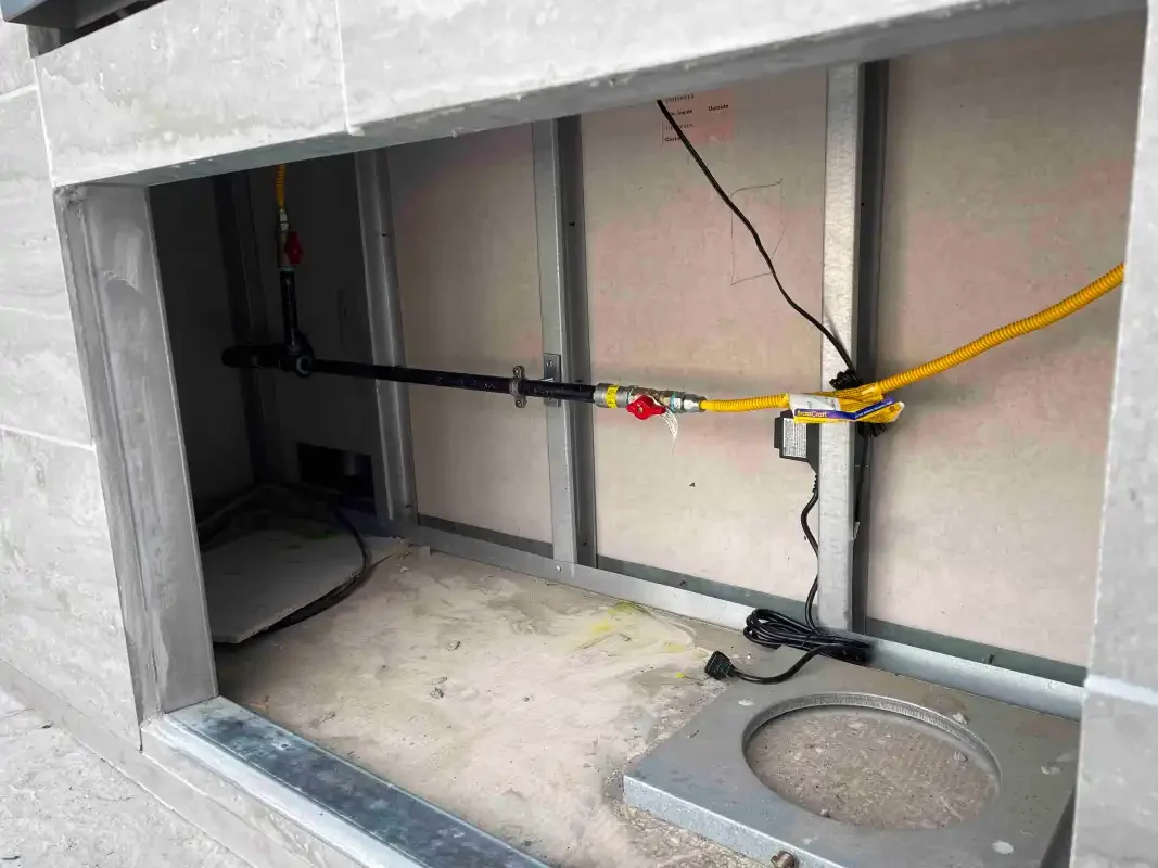 Under-slab rough-in opening in a garage with yellow gas line run overhead