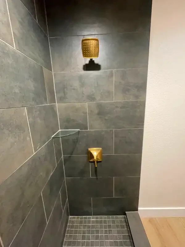 Slate-tiled walk-in shower with brass fixtures