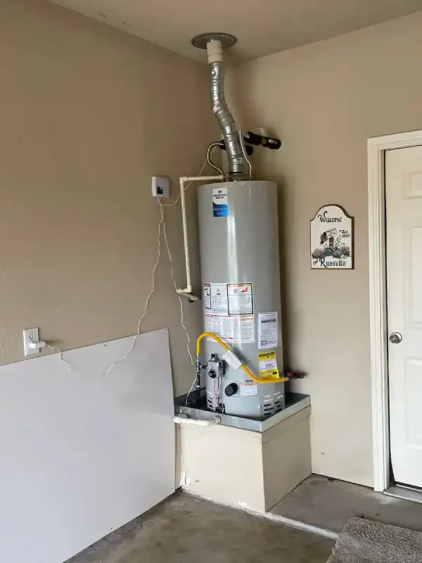 Gas water heater on a garage platform with vent flue
