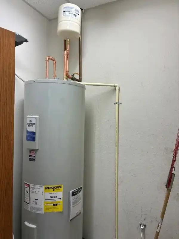Electric tank water heater with copper lines in a utility space