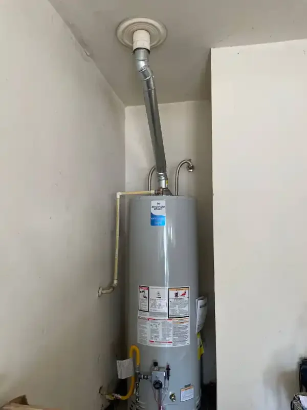 Gas tank water heater in a narrow interior closet with flue